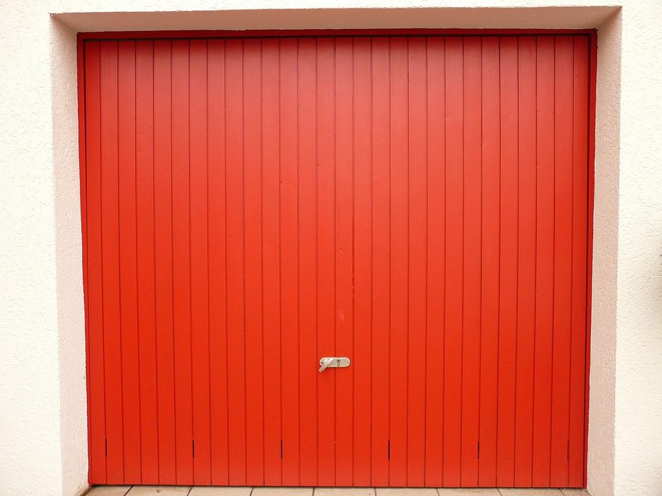 Puerta de garaje roja cerrada con paneles verticales
